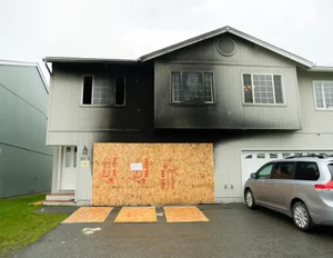 Home with boarded windows after fire or storm damage