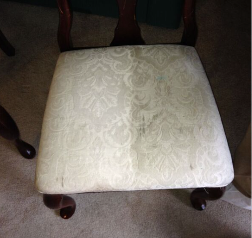 Upholstered chair showing staining or damage requiring cleaning