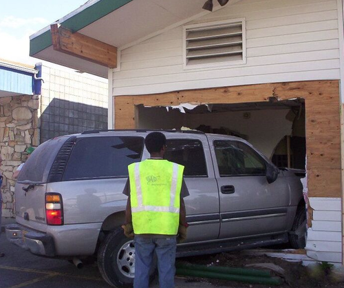 Technician inspecting property exterior during restoration service