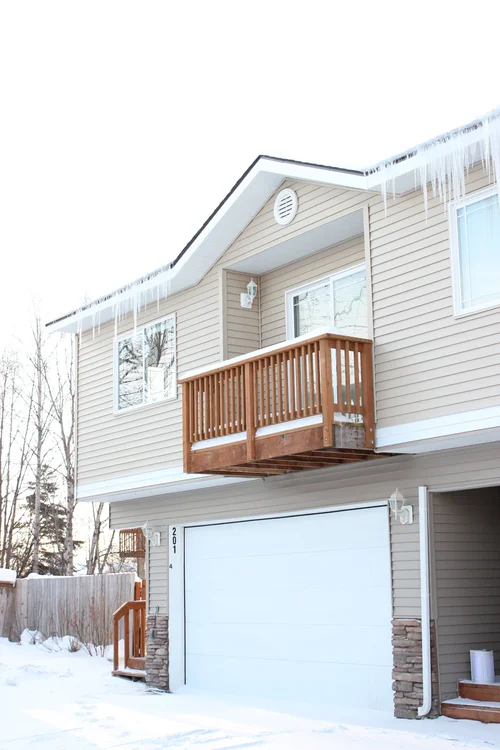 Restored home exterior with updated siding and balcony