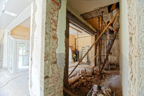Exposed wall framing and structural damage during restoration process